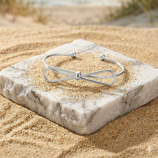 Silver bracelet on a stone with sand in the background