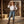 Load image into Gallery viewer, A woman stands in a rustic barn wearing a white long-sleeve button-up shirt, blue jeans, a brown western belt with a silver buckle, brown cowboy boots, and a tan cowboy hat.
