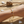 Load image into Gallery viewer, Gold bracelet with a diamond on a wrist against a sandy background
