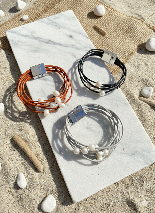 Three bracelets on a marble surface with a beach setting