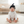 Load image into Gallery viewer, Baby sitting on a rug in a nursery wearing a black hat and white onesie with a bandana.
