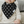 Load image into Gallery viewer, Baby wearing a black bib with white cross patterns, sitting on a couch.
