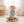 Load image into Gallery viewer, Baby sitting on a carpeted floor holding a colorful toy, wearing a green bib.
