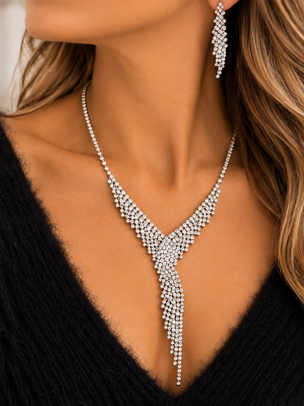 Silver rhinestone Y-drop necklace worn by woman in black sweater