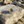 Load image into Gallery viewer, Metallic spoon on a textured stone surface with sand and driftwood in the background
