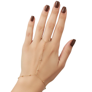 Hand wearing a delicate gold bracelet on a plain background