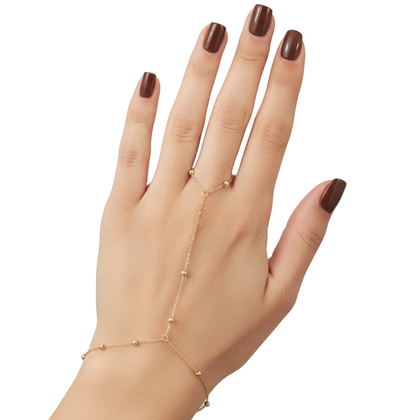 Hand wearing a delicate gold bracelet on a plain background