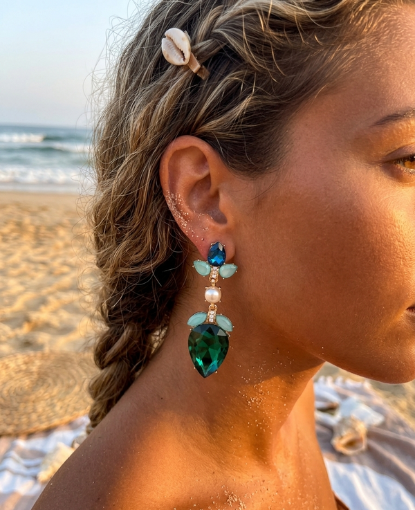 Woman on a beach wearing turquoise earrings with a blurred background
