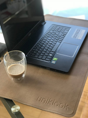 tan vegan leather on a desk under a computer, mat is shown as a desk mat